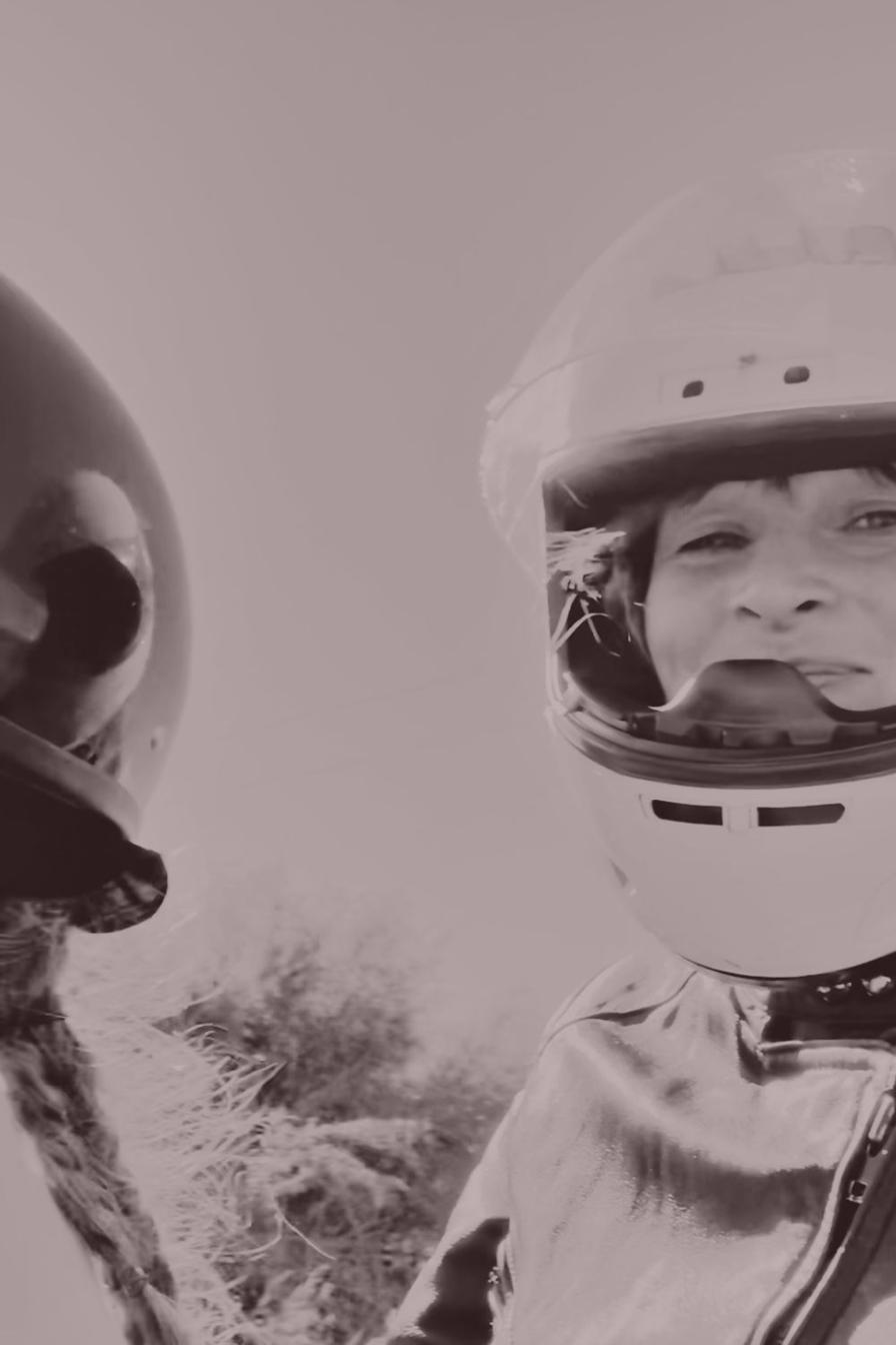 Rita and her mother laughing together in motorcycle helmets
