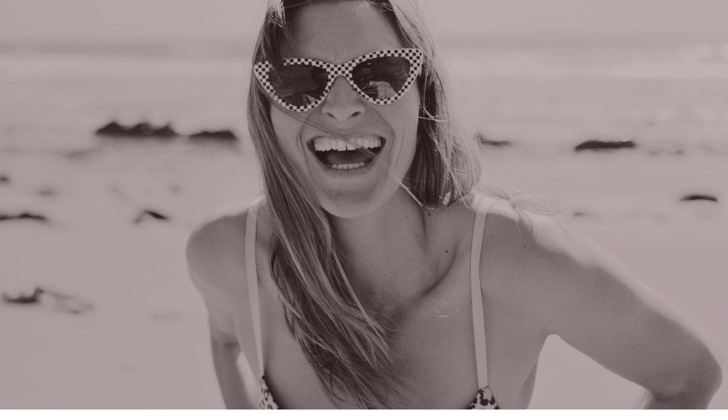 Rita laughing on the beach, wind in her hair