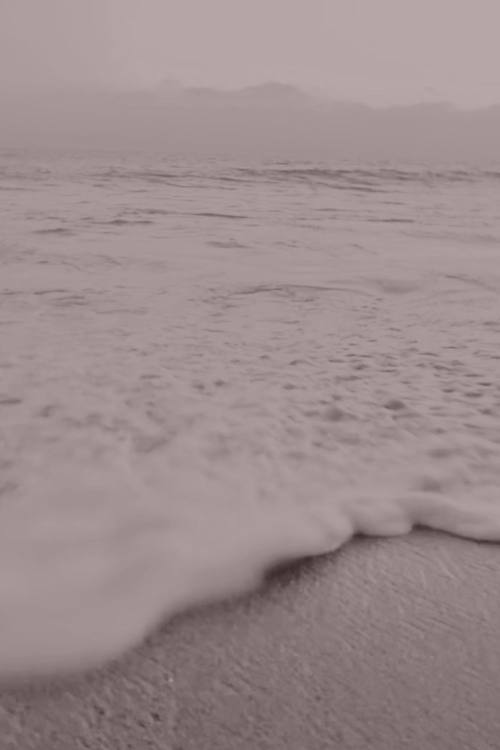 A wave meeting the sand at the shoreline